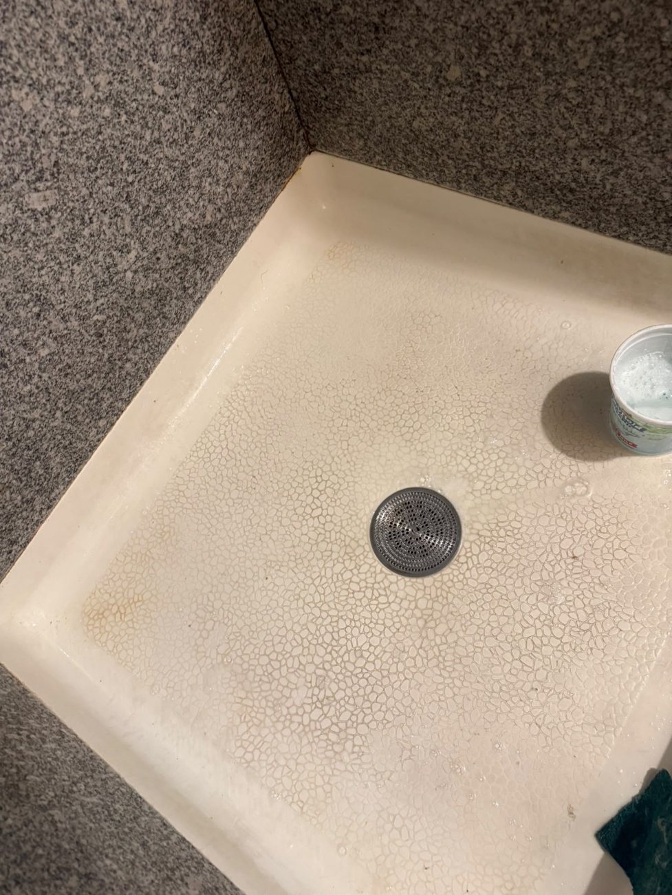 Stained shower pan before cleaning